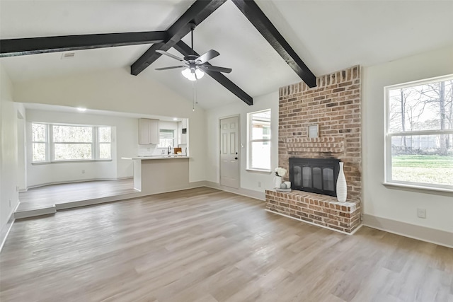 unfurnished living room with ceiling fan, light wood-style floors, plenty of natural light, and a brick fireplace