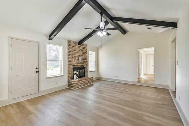 unfurnished living room with a ceiling fan, baseboards, light wood finished floors, lofted ceiling with beams, and a fireplace