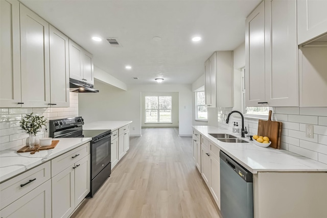 kitchen featuring visible vents, under cabinet range hood, dishwasher, black / electric stove, and a sink