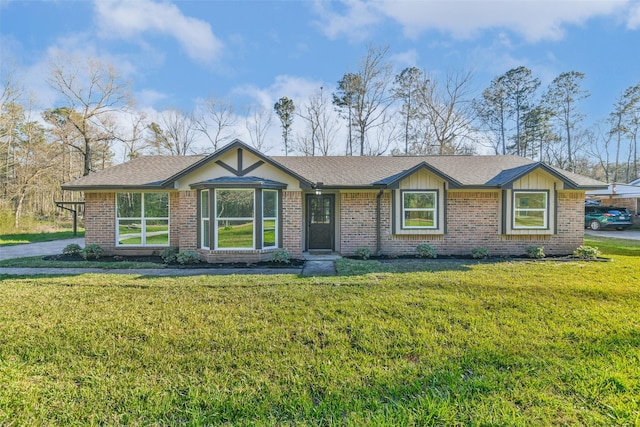 ranch-style house with brick siding, roof with shingles, and a front yard