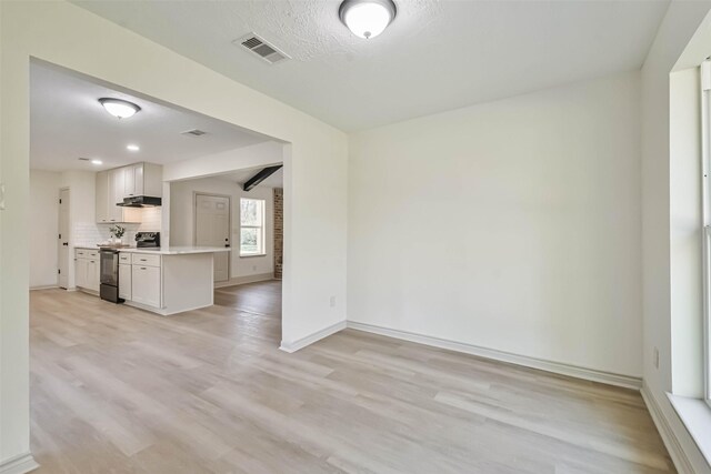 spare room featuring visible vents, light wood-type flooring, and baseboards