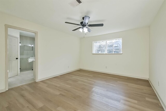 unfurnished bedroom featuring connected bathroom, light wood-style floors, visible vents, and baseboards