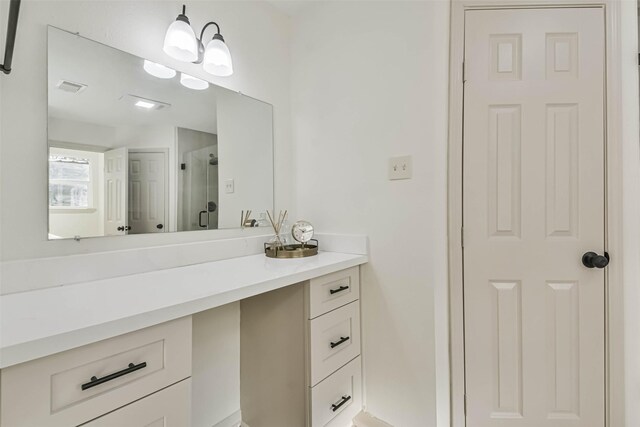 bathroom with visible vents, a stall shower, and vanity