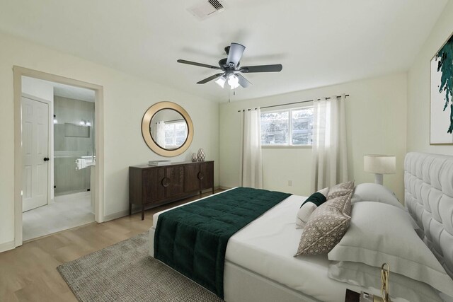 bedroom featuring visible vents, baseboards, light wood-style flooring, ensuite bathroom, and a ceiling fan