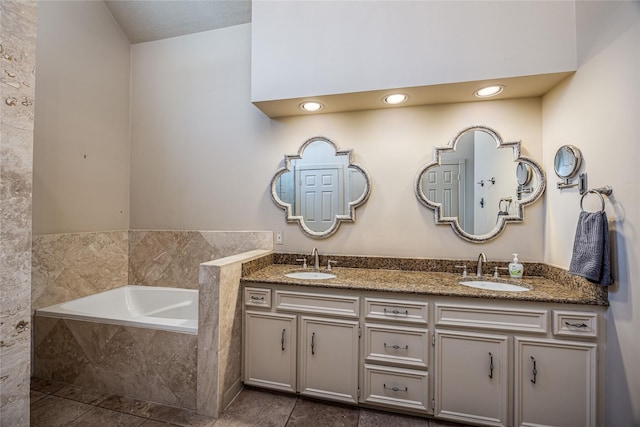 full bathroom featuring a garden tub, double vanity, a sink, and tile patterned floors