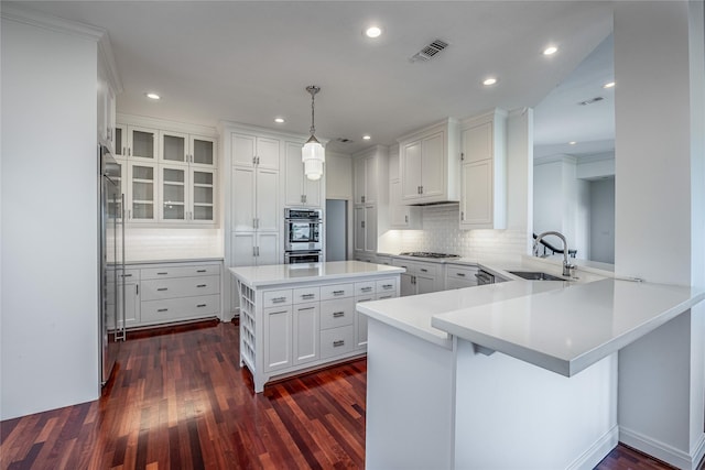 kitchen featuring dark wood-style flooring, a sink, gas stovetop, and white cabinetry