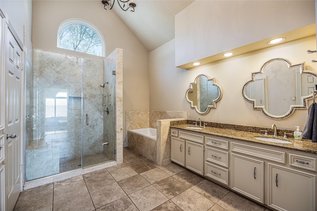 full bath featuring vaulted ceiling, double vanity, a stall shower, and a sink