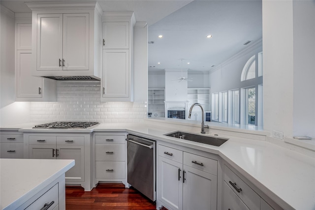 kitchen featuring crown molding, stainless steel appliances, light countertops, white cabinetry, and a sink