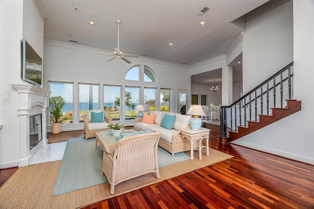 living room with ornamental molding, a high end fireplace, wood finished floors, and stairs