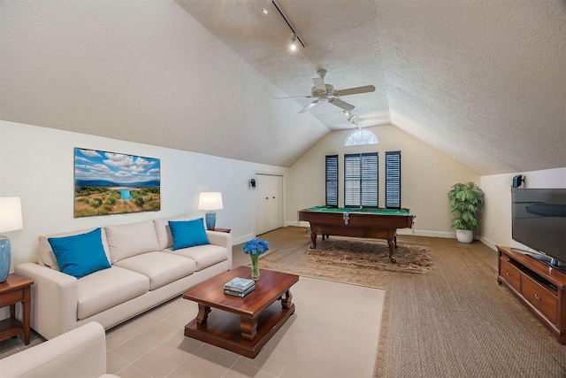 game room featuring baseboards, a ceiling fan, rail lighting, vaulted ceiling, and a textured ceiling