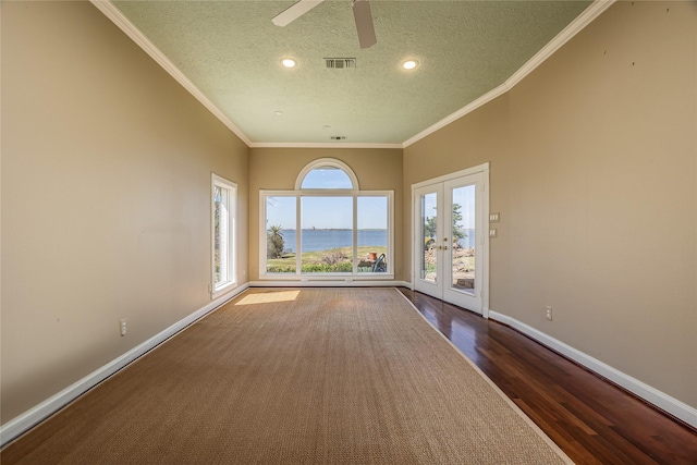 spare room featuring visible vents, baseboards, ornamental molding, french doors, and dark wood finished floors