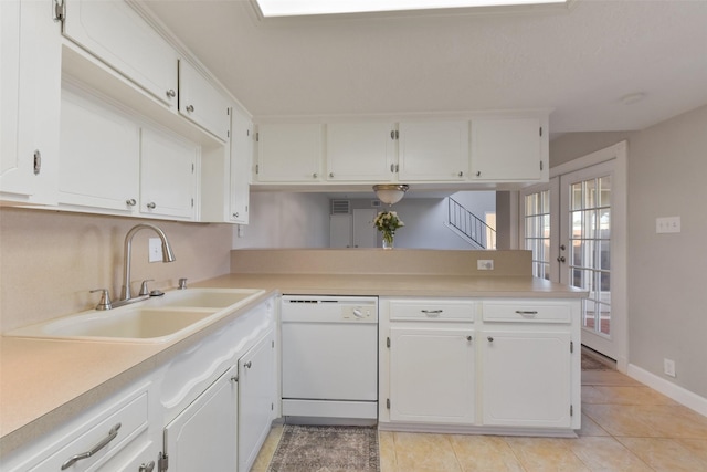 kitchen with light countertops, white cabinets, white dishwasher, and a sink