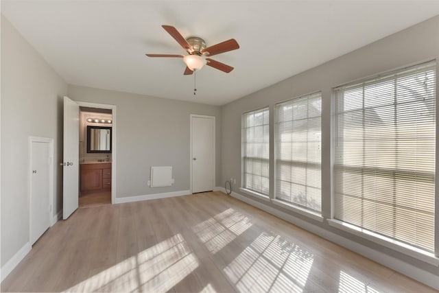 spare room with a ceiling fan, baseboards, and light wood finished floors