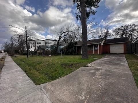 view of front of property featuring driveway, a garage, and a front lawn