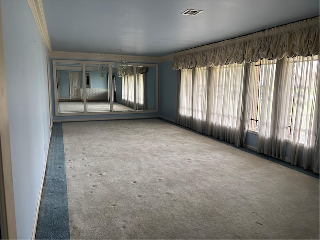 carpeted empty room featuring visible vents, a healthy amount of sunlight, and crown molding