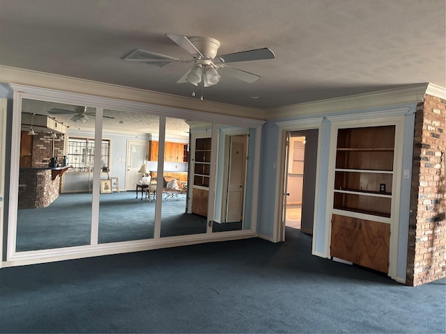 carpeted empty room featuring crown molding and a ceiling fan