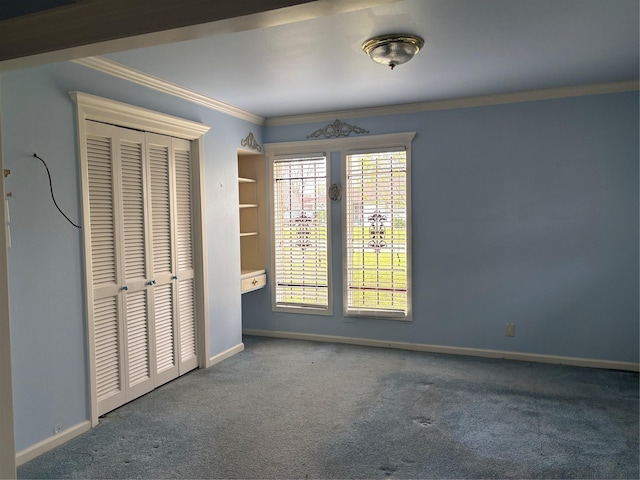 unfurnished bedroom with crown molding, carpet, baseboards, and a closet