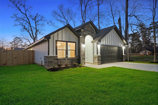 view of front of home featuring an attached garage, stone siding, board and batten siding, and a front yard