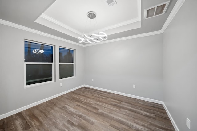 spare room with dark wood-type flooring, a raised ceiling, visible vents, and a chandelier