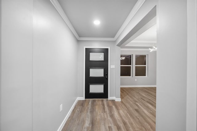 entryway with a notable chandelier, baseboards, ornamental molding, and wood finished floors