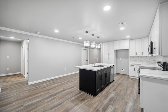 kitchen with visible vents, decorative backsplash, stainless steel appliances, light countertops, and a sink