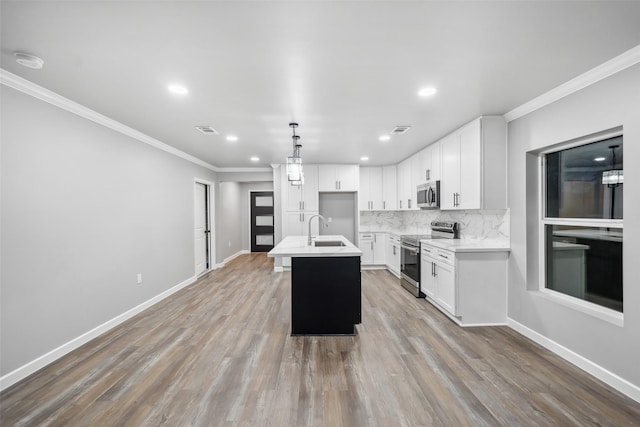 kitchen with appliances with stainless steel finishes, visible vents, a sink, and decorative backsplash