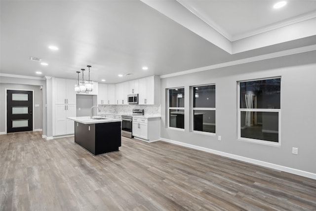 kitchen with appliances with stainless steel finishes, light countertops, crown molding, and a sink