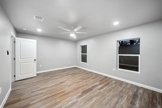 unfurnished room with ceiling fan, recessed lighting, wood finished floors, visible vents, and baseboards