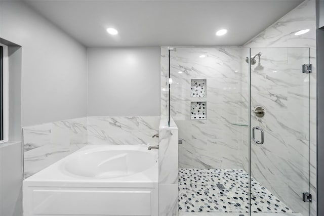 full bathroom with a stall shower, a garden tub, and recessed lighting