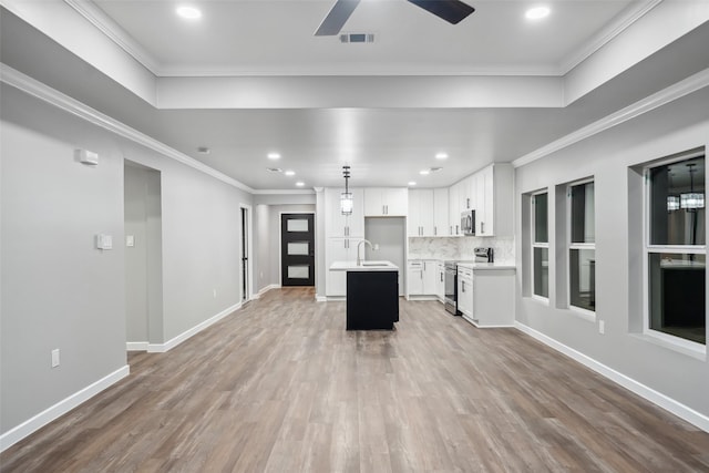 kitchen featuring ornamental molding, appliances with stainless steel finishes, and a center island with sink