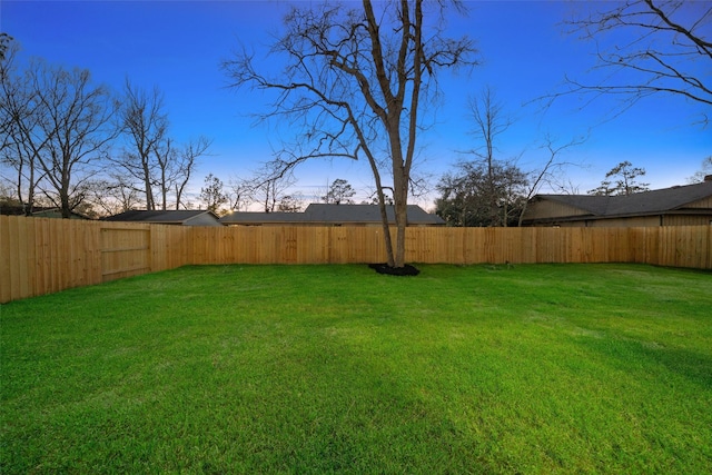 yard at dusk with a fenced backyard