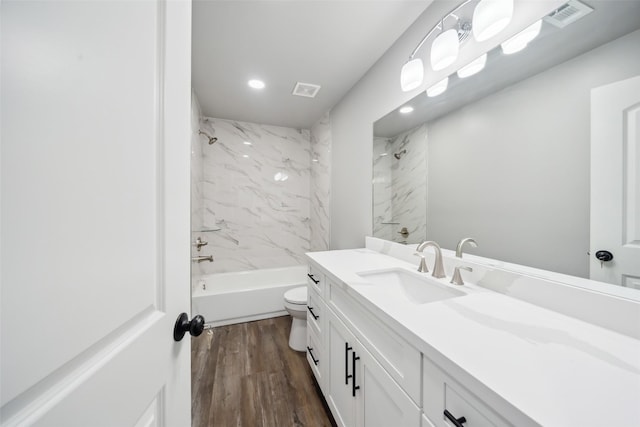 full bath featuring visible vents, toilet, vanity, wood finished floors, and  shower combination