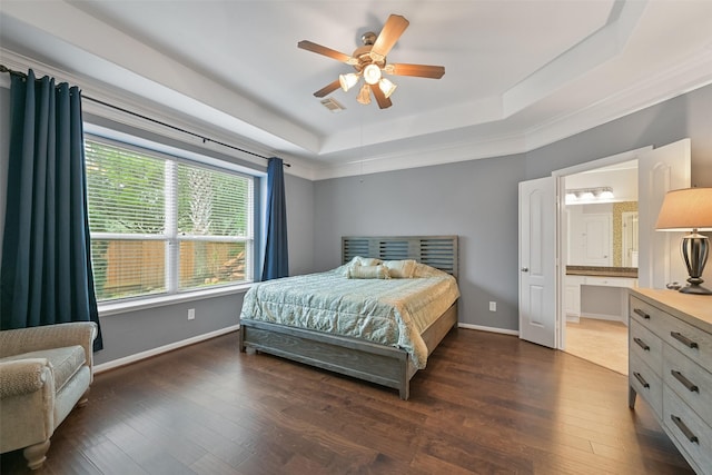 bedroom featuring wood finished floors, a raised ceiling, visible vents, and baseboards