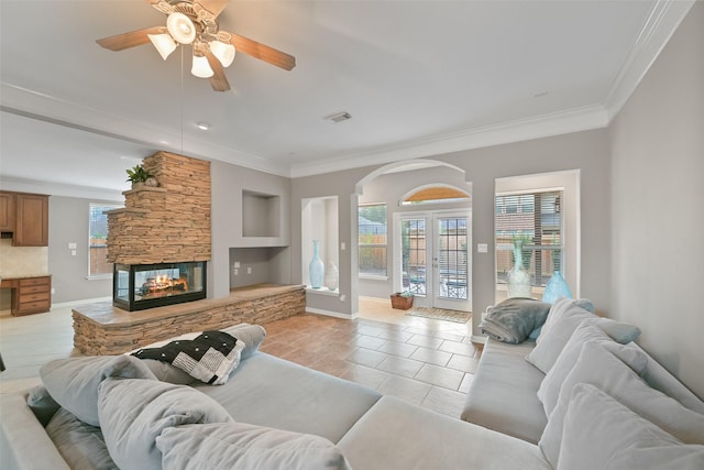 living room with french doors, crown molding, light tile patterned floors, visible vents, and a stone fireplace