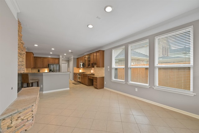 kitchen featuring brown cabinetry, baseboards, glass insert cabinets, and stainless steel refrigerator with ice dispenser