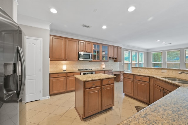 kitchen with tasteful backsplash, visible vents, appliances with stainless steel finishes, ornamental molding, and a sink