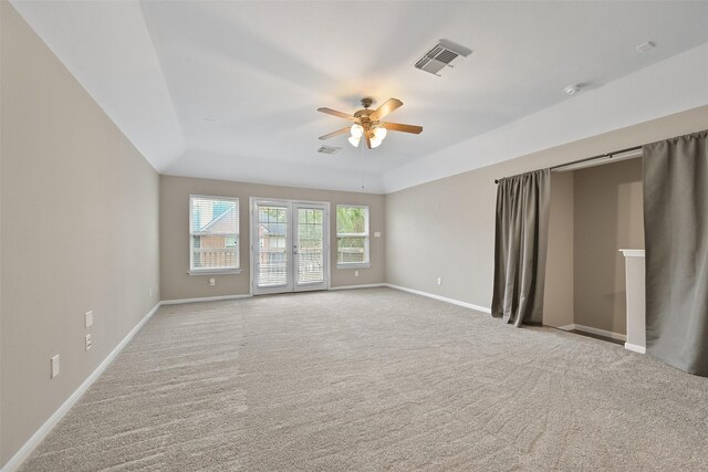 spare room with ceiling fan, visible vents, baseboards, french doors, and a tray ceiling