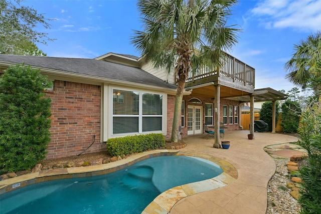 back of house featuring a patio area, french doors, brick siding, and an outdoor pool