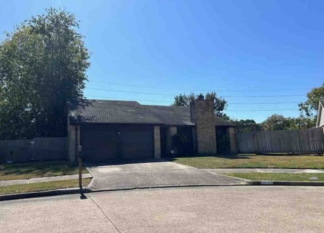 ranch-style home featuring a front lawn, driveway, an attached garage, and fence