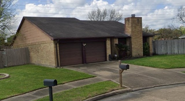 single story home featuring driveway, fence, a front lawn, and brick siding