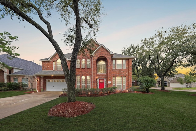 view of front of house featuring a garage, a lawn, concrete driveway, and brick siding