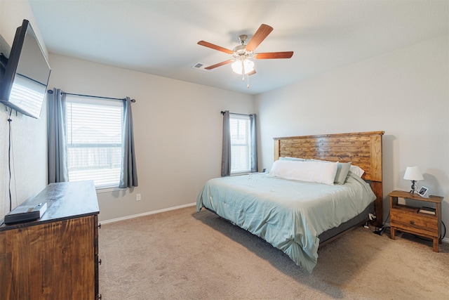 bedroom with baseboards, a ceiling fan, visible vents, and light colored carpet