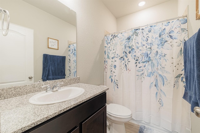 full bathroom with toilet, wood finished floors, and vanity