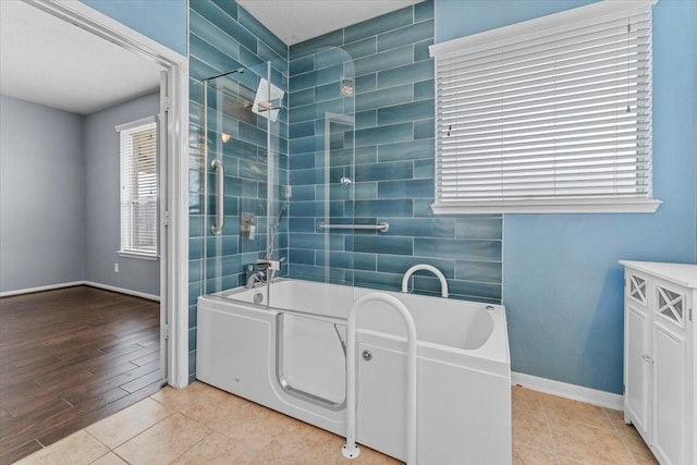 full bath featuring baseboards,  shower combination, and tile patterned floors