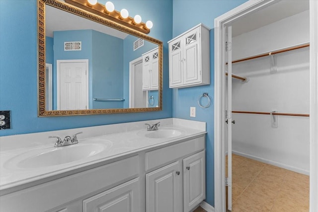 full bathroom with a sink, a spacious closet, and double vanity