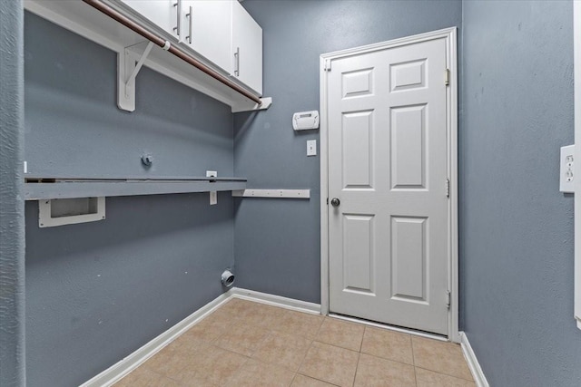 washroom featuring cabinet space, light tile patterned floors, baseboards, washer hookup, and electric dryer hookup