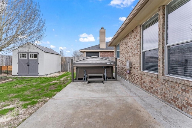 view of patio / terrace with a shed, an outdoor structure, and a fenced backyard