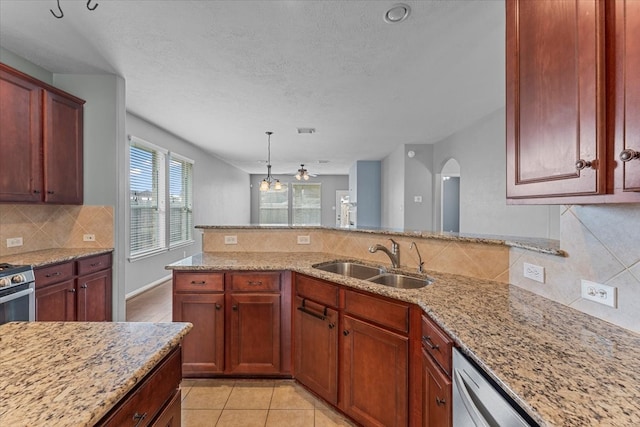 kitchen featuring arched walkways, visible vents, backsplash, a sink, and light stone countertops