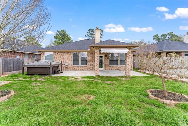 rear view of house with brick siding, a yard, a chimney, a patio area, and a fenced backyard