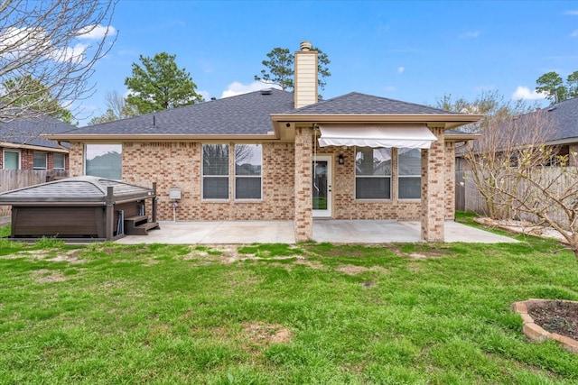 rear view of property with a yard, a chimney, fence, and a patio